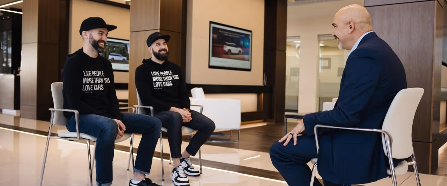 Kyle interviewing a dealer in a modern lobby